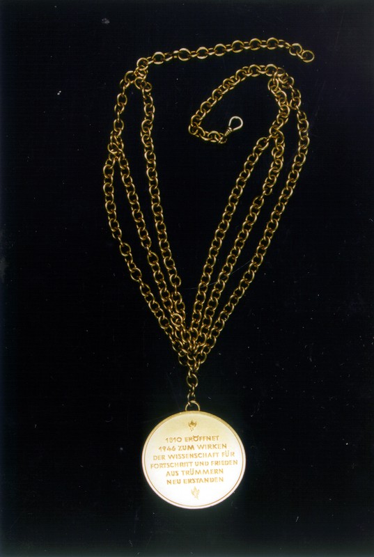 Georg Stapel, Rektor-Amtskette, Silber vergoldet/ Kette Nickel vermessingt, 1960, Inv.-Nr. A 019, Revers: „1810 ERÖFFNET / 1946 ZUM WIRKEN / DER WISSENSCHAFT FÜR / FORTSCHRITT UND FRIEDEN / AUS TRÜMMERN / NEU ERSTANDEN“; oben: Lorbeerblatt nach links; unten: Lorbeerblatt nach rechts; unsigniert