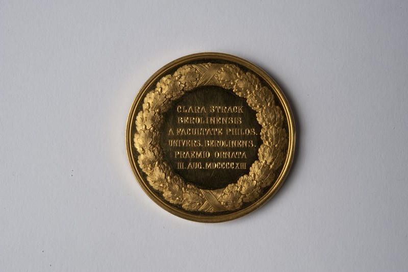  Carl Friedrich Voigt (Stempel), Preismedaille für Clara Strack, Gold, 1913, Inv.-Nr. A 091, Revers: CLARA STRACK BEROLINENSIS A FACULTATE PHILOS. UNIVERS. BEROLINENS. PRAEMIO ORNATA III. AUG. MDCCCCXI